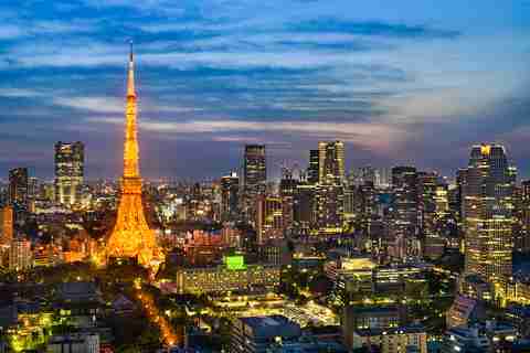 Vue nocturne du skyline de Tokyo illuminé par des néons colorés, représentant l'énergie vibrante de la ville.